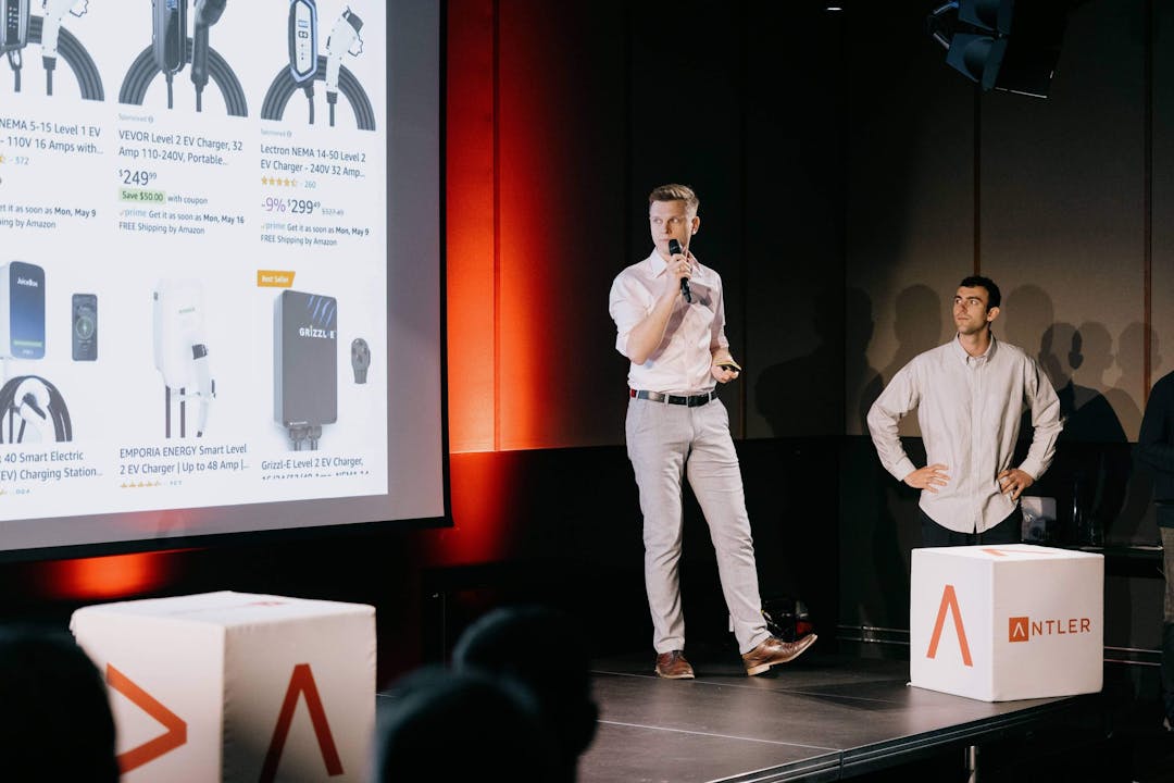 Co-founders on stage with presentation screen