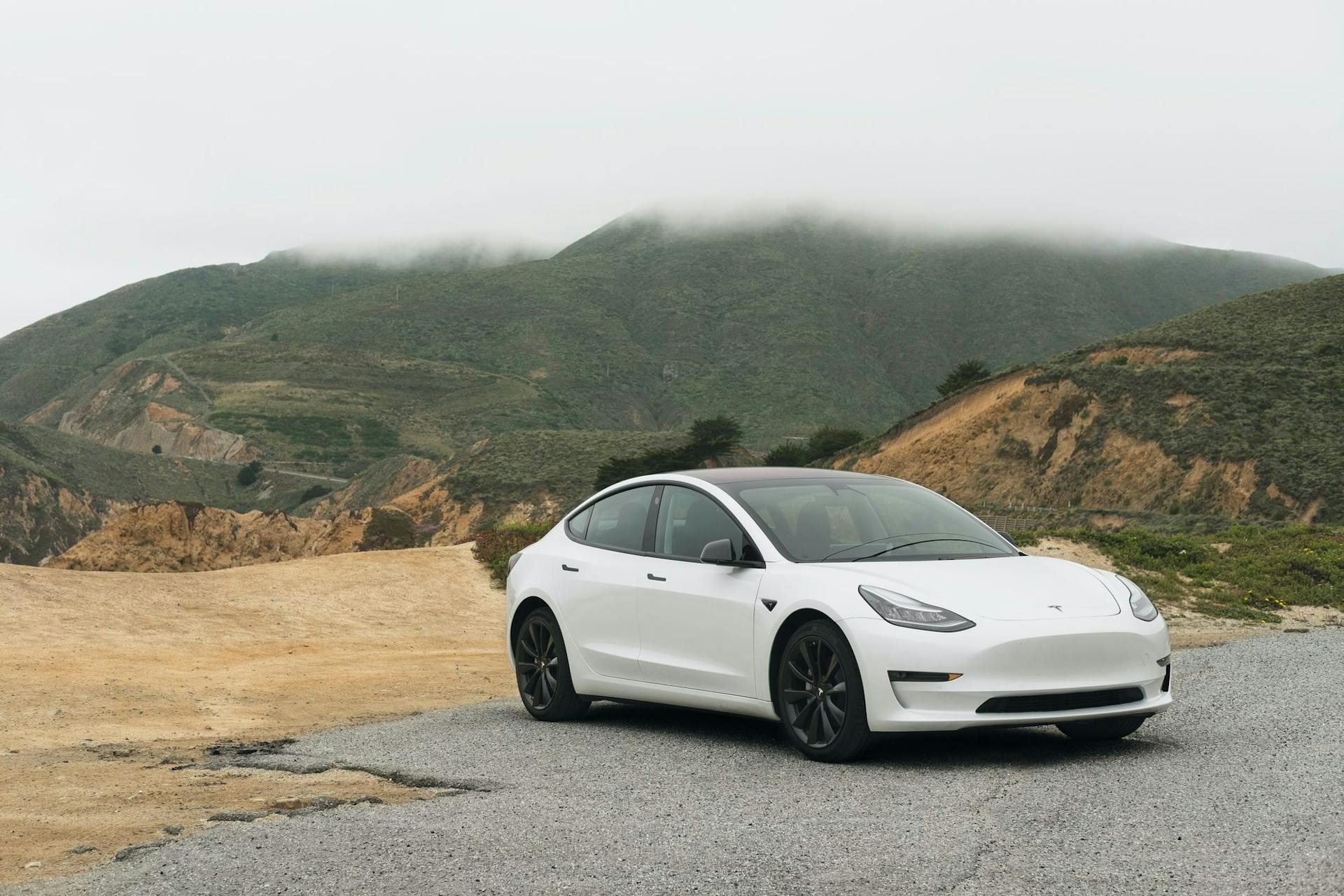 White electric vehicle parked in mountains