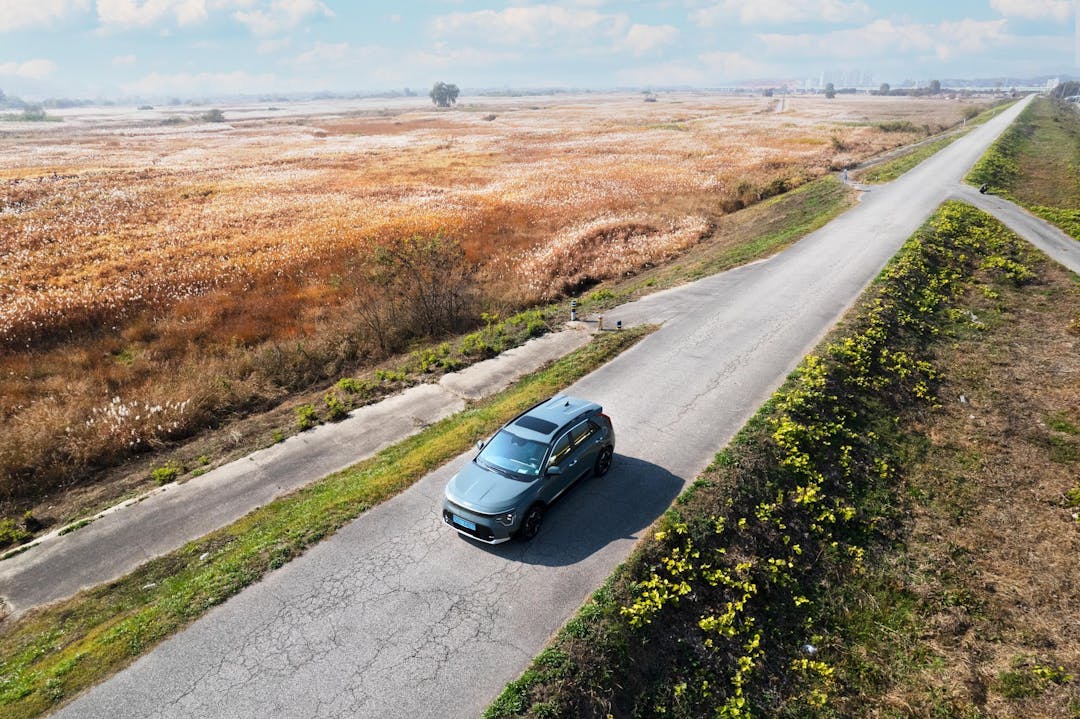 Blue EV driving on road in the countryside